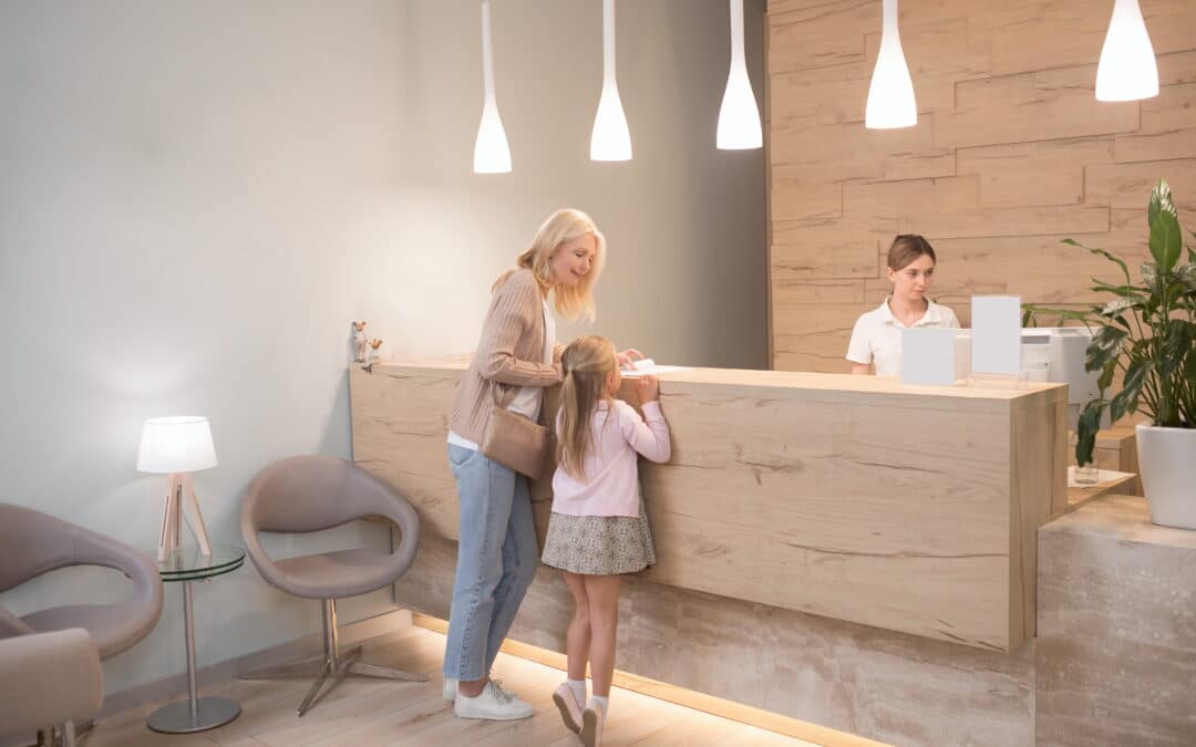 mom and daughter checking in to a dental office at the front desk